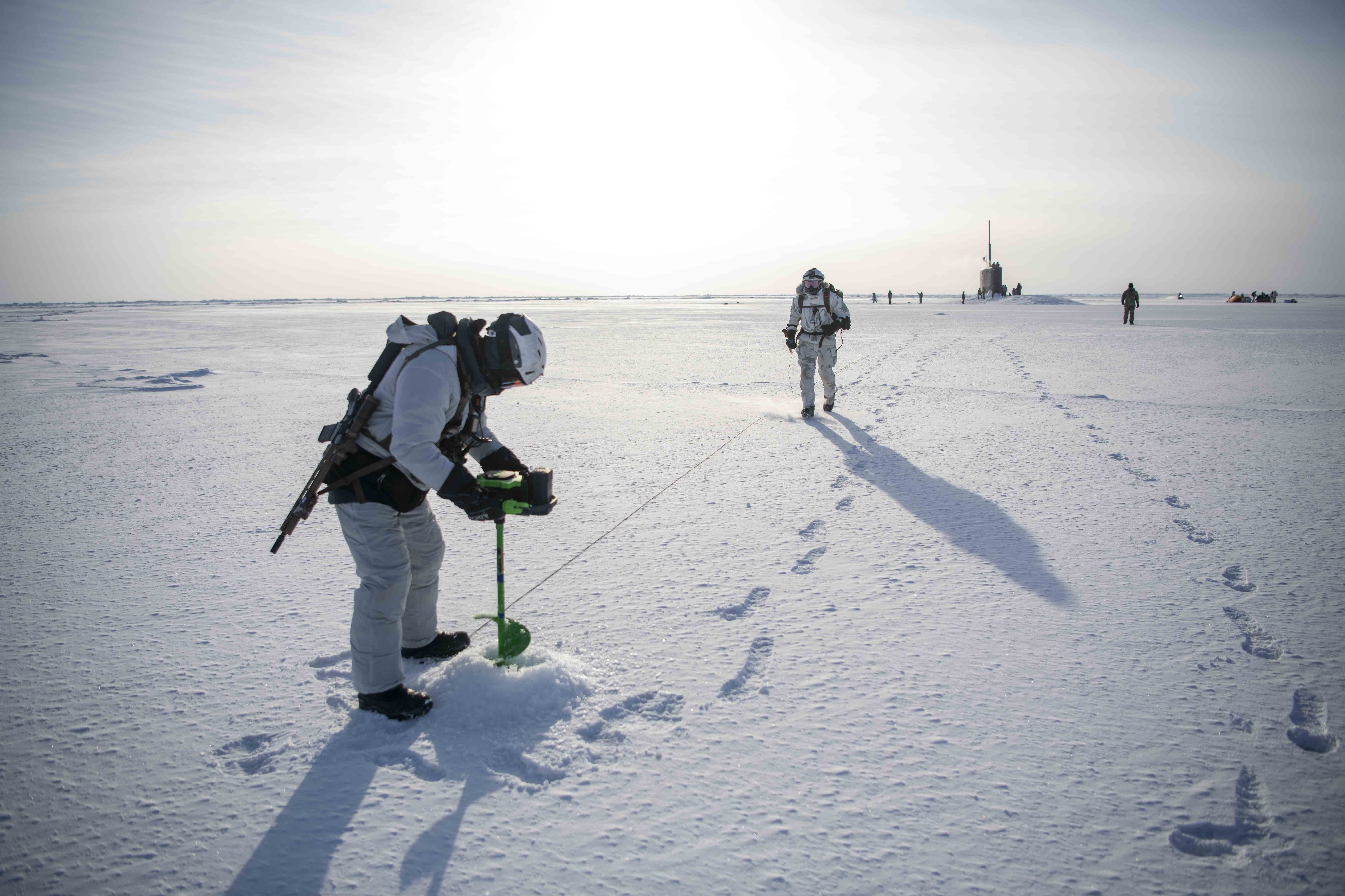 East Coast–based Naval Special Warfare Operator and Norwegian naval special operations commandos test ice thickness next to Los Angeles–class attack submarine USS Hampton to establish landing zone for MH-47G Chinook helicopter assigned to 160th Special Operations Aviation Regiment (Airborne) during integration exercise, March 9, 2024, as part of Arctic Edge 24, Arctic Ocean (U.S. Navy/Jeff Atherton)